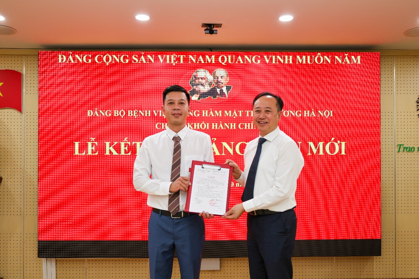 Đồng chí Trần Cao Bính, Bí thư Đảng ủy, Bí thư Chi bộ Khối Hành chính, Giám đốc Bệnh viện trao quyết định kết nạp đảng cho đồng chí Nguyễn Xuân Tiến